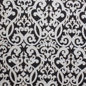 May include: A black and white damask pattern fabric with a repeating design of swirling floral motifs.