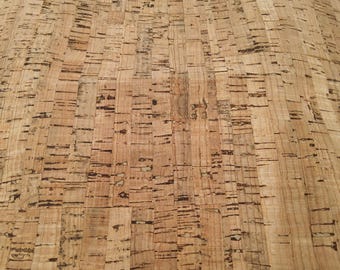 May include: Close-up of a cork surface with a natural, light brown color. The cork has a textured appearance with dark brown lines and patterns, creating a rustic and organic aesthetic. The surface is made of rectangular pieces.