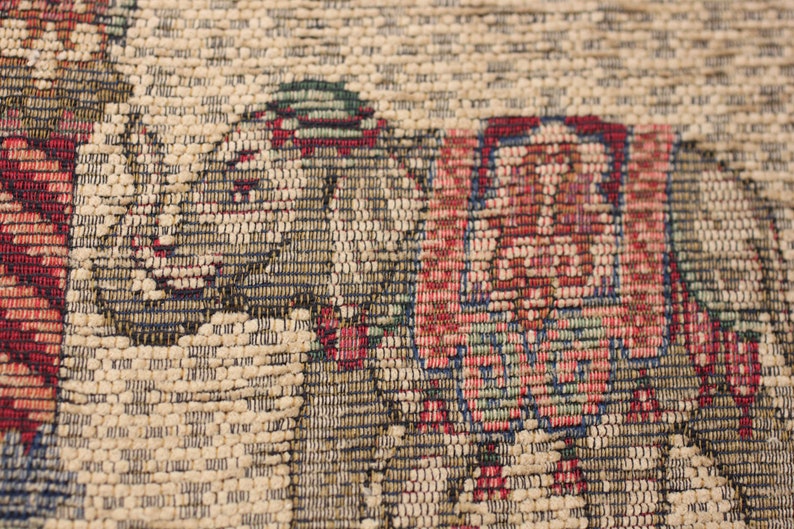 May include: Close-up of a tapestry featuring a detailed woven design of two elephants in shades of red, blue, green, and brown.