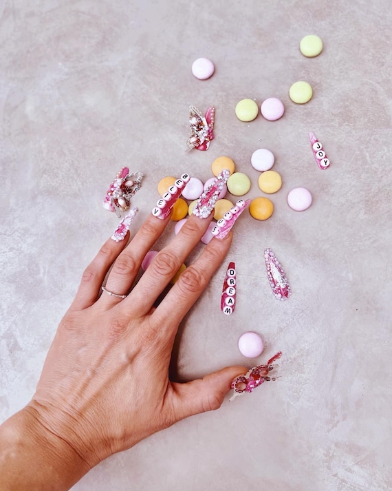 Premium Photo | Light pink nail design with white lines, rhinestones,  glitter with gladiolus.