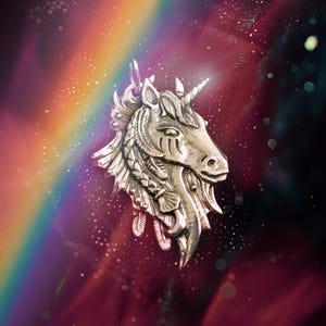 May include: A silver unicorn pendant with intricate details, set against a blurred background of a rainbow and sparkling lights.