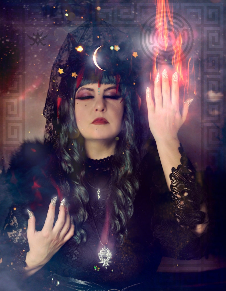 May include: A woman with dark blue hair and a black lace veil, wearing a black dress with a silver pendant, stands with her hands raised in front of a background of flames and a swirling galaxy.