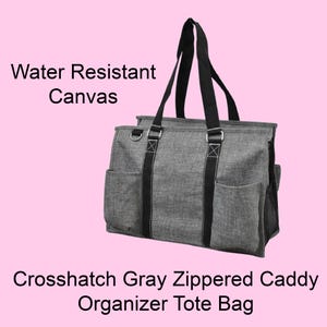 May include: Gray crosshatch zippered caddy organizer tote bag made of water-resistant canvas. Features black handles and accents, multiple exterior pockets, and a zippered top. The bag has a rectangular shape and is designed for organization.