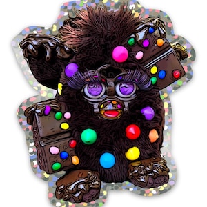 May include: A brown furry toy with a pink, purple, and green face. The toy is covered in colourful candy-like dots and has a chocolate bar on its side.