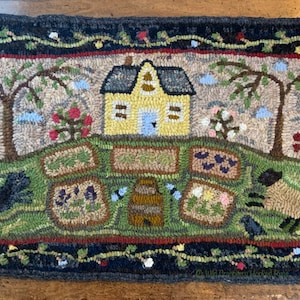 May include: A hand-hooked rug depicting a yellow house with a blue door, two trees, and a garden with flowers and a barrel. Two black dogs are running in the grass. The rug has a black border with a vine pattern.