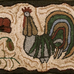 May include: A colourful rug featuring a rooster and flowers. The rooster is green, blue and brown. The flowers are red, blue and green. The rug is made of wool and has a textured surface.