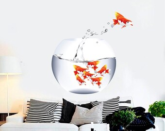 Könnte beinhalten: Ein weißer Wandaufkleber mit einem Aquarium mit orangefarbenen Goldfischen, die darin schwimmen. Ein Goldfisch springt aus dem Aquarium.