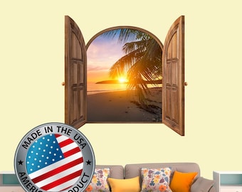 Op de afbeelding: Een decoratieve muursticker met een houten raamkozijn met een gebogen opening. Het raam opent naar een tropisch strandbeeld met een palmboom en een zonsondergang. De sticker is gemaakt in de VS en heeft een zilveren en rode Amerikaanse vlag met de woorden "Made in the USA American Product".