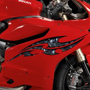 May include: A red Ducati motorcycle with a black and silver flame design on the side. The motorcycle has a black seat and a black exhaust pipe.