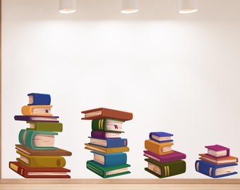 May include: A white wall with four light fixtures hanging from the ceiling. There are four stacks of colorful books on the wall, each stack getting smaller in size. The largest stack is on the left and the smallest stack is on the right.