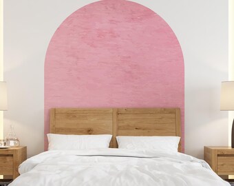 Puede incluir: Una cama blanca con un edredón blanco y una cabecera arqueada rosa en un dormitorio con dos mesitas de noche y lámparas.