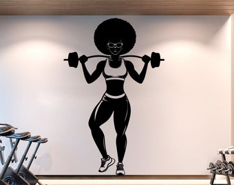 Può includere: Silhouette in bianco e nero di una donna che solleva un bilanciere in una palestra. La donna indossa un reggiseno sportivo e leggings. Sullo sfondo ci sono delle biciclette da palestra.