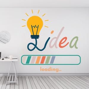 May include: A white wall with a large graphic of a yellow lightbulb with the word "Idea" and a loading bar. A white desk with a laptop and accessories sits in front of the wall. The floor is made of light-colored wood.