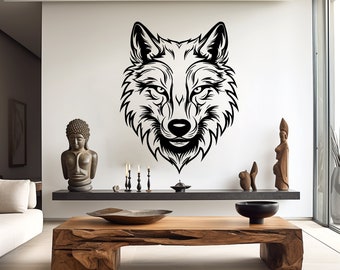 May include: Black and white wolf head silhouette wall decal. The decal is on a white wall in a modern living room with a wooden coffee table and decorative statues.