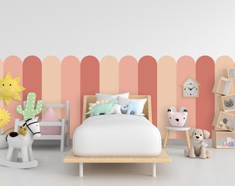 Op de afbeelding: Een wit houten bed met een wit matras en een wit schommelpaard ervoor. Het bed heeft twee kussens en een groen en blauw dinosaurus knuffeldier. De muur achter het bed heeft een roze en oranje gestreept patroon.