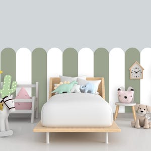 May include: A child's bedroom scene with a wooden bed, white bedding, and dinosaur-shaped pillows. The room features a rocking horse, a cactus, a sun-shaped pillow, a chair with a bear-shaped back, and a dog plushie. The wall has a green and white striped pattern.