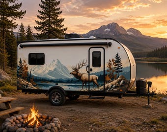 May include: A white travel trailer featuring a large graphic mural on its side depicting a majestic elk standing in a mountain landscape with a lake and pine trees. The trailer has a single door, a window, and black wheels, parked near a campfire.