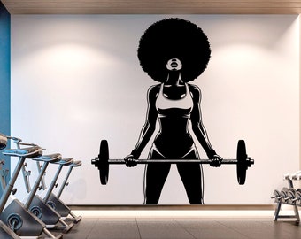Può includere: Silhouette in bianco e nero di una donna con un afro che solleva un bilanciere in una palestra. La donna indossa un reggiseno sportivo e pantaloncini corti. Sullo sfondo ci sono delle cyclette.
