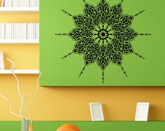 May include: A black and white mandala wall decal with intricate geometric patterns. The decal is applied to a green wall in a living room setting.