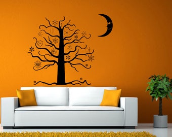 May include: A black silhouette of a tree with snowflakes on an orange wall. A black crescent moon with a face is on the wall. A white couch with orange throw pillows is in front of the wall. A potted plant is on the right side of the image.
