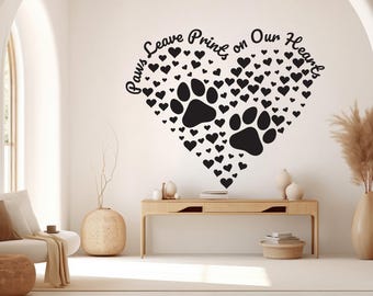 May include: Black and white wall decal with a heart shape made of paw prints and hearts. The text "Paws Leave Prints on Our Hearts" is written around the heart.