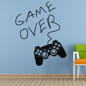 May include: Black and white wall decal of a video game controller with the words "GAME OVER" written above it.