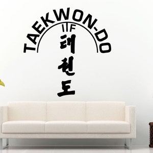 Puede incluir: Pegatina de pared en blanco y negro con el texto "TAEKWON-DO" en un semicírculo sobre los caracteres coreanos para "Taekwondo" y las letras "IIF" en el centro del semicírculo.