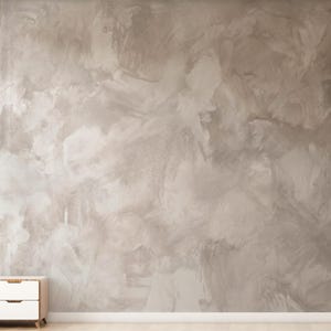May include: A wall covered in wallpaper featuring a mottled, hand-painted effect in shades of light gray, beige, and off-white. The surface displays visible brushstrokes and blended textures, creating a cloudy, layered appearance across the entire wall.