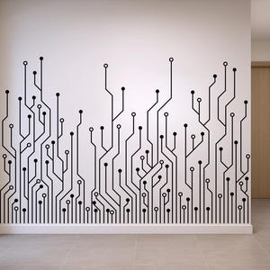 May include: Black and white circuit board wall decal. The design features a network of lines and circles, creating a modern, tech-inspired aesthetic. The decal is applied to a white wall, adding a graphic element to the interior space.