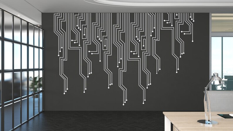 May include: A modern office interior with a black wall featuring a white circuit board design. A wooden desk with a lamp sits in the foreground.