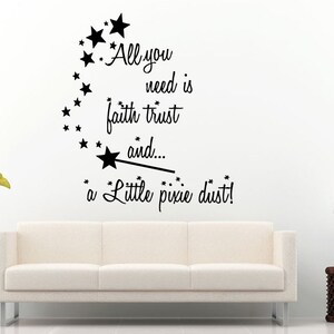 May include: A wall decal with the text "All you need is faith trust and... a Little pixie dust!" in black script and star accents. The decal is displayed above a white sofa and a side table with a lamp.
