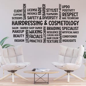 Puede incluir: Un vinilo de pared con las palabras "Peluquería y Cosmetología" y términos relacionados como "Estilista", "Maquillaje" y "Faciales". Dos sillones blancos y una pequeña mesa de madera con un libro están frente a la pared. Hay plantas en macetas a ambos lados.