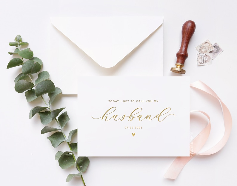 Personalized wedding day card reading “Today I Get to Call You My Husband” in gold foil with custom wedding date, modern minimalist bride to groom wedding card styled flat lay with envelope, ribbon, and eucalyptus.