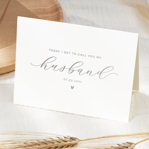 Personalized wedding day card reading “Today I Get to Call You My Husband” in silver foil with custom wedding date, modern minimalist bride to groom wedding card styled on neutral linen fabric.