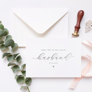 Personalized wedding day card reading “Today I Get to Call You My Husband” in silver foil with custom wedding date, modern minimalist bride to groom wedding card styled flat lay with envelope, ribbon, and eucalyptus.