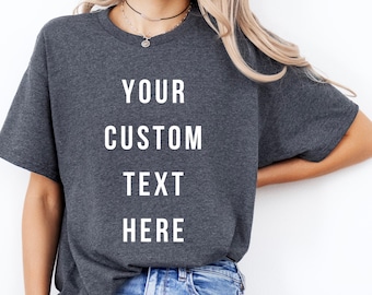 May include: Dark gray t-shirt with the words "YOUR CUSTOM TEXT HERE" in white block letters. The shirt is a crew neck style with short sleeves. The model is wearing blue jeans.