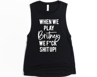 May include: Black sleeveless tank top with white text that reads "WHEN WE PLAY Britney WE F*CK SHIT UP!" The shirt has a scoop neck and a relaxed fit. The text is in a mix of fonts.