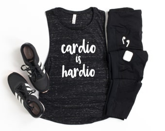 May include: Black tank top with the text "cardio is hardio" in white lettering. The tank top is paired with black leggings, black sneakers, and white wireless earbuds.