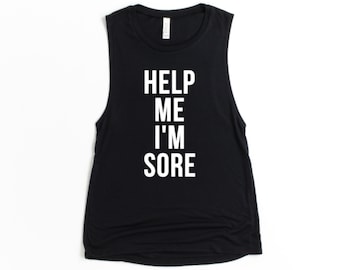 May include: Black sleeveless muscle tank top with white text that reads "HELP ME I'M SORE".