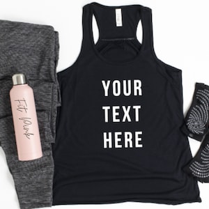 May include: Black tank top with the text "YOUR TEXT HERE" in white. The tank top is paired with gray leggings, a pink water bottle with the text "Fit Pink", and black and silver yoga socks.