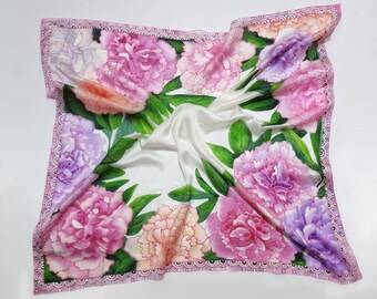 May include: A white silk scarf with a pink, purple, and peach floral design. The scarf has a pink and white lace trim.