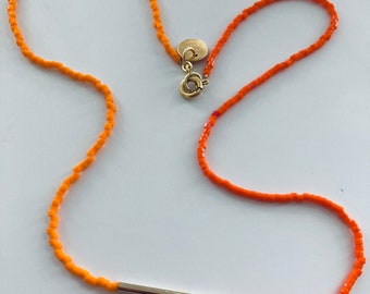 Two orange Miyuki  beads necklace ended with a medallion.