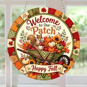 May include: A round hanging sign featuring a squirrel sitting in a wheelbarrow filled with pumpkins and sunflowers. The text reads Welcome to Our Patch and Happy Fall. The border consists of a colorful patchwork pattern in red, green, and orange.