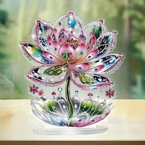 Pode incluir: Uma escultura decorativa de flor de lótus com base transparente. A flor apresenta tons rosa, azul, verde e amarelo, adornados com detalhes brilhantes. As pétalas são detalhadas com um efeito gradiente, criando um design vibrante e atraente.