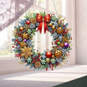 May include: A circular festive wreath featuring green pine needles, a large red bow at the top, and various ornaments including gold stars, red and purple spheres, pinecones, and small berries. The wreath is decorated with sparkling accents.