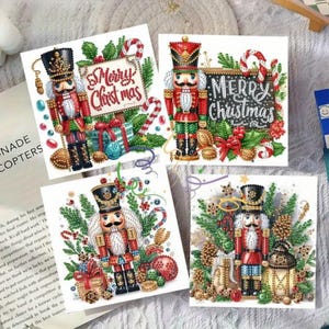 May include: Four square Christmas cards featuring nutcracker soldiers. Each card has a different design, including the words "Merry Christmas" and festive decorations like candy canes, gifts, and greenery.
