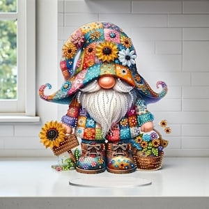 May include: A colorful gnome figurine with a long white beard, wearing a patchwork hat and outfit. The gnome holds a sunflower and a basket of flowers. The boots are decorated with floral patterns. The figurine is on a clear, round stand.