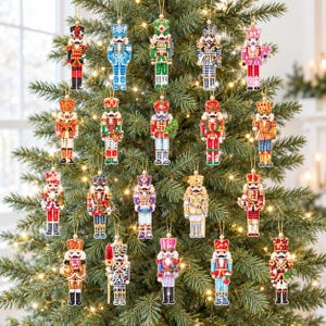 May include: A collection of twenty nutcracker ornaments featuring intricate beadwork in various colors including red, blue, green, gold, and pink. Each ornament is suspended by a gold string and displays a unique uniform design with a hat.