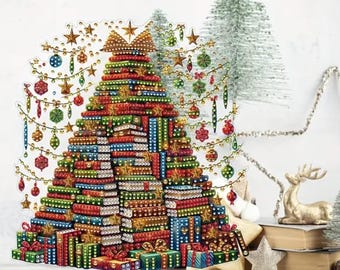 May include: A Christmas tree made of stacked gift boxes in red, green, and blue, adorned with gold stars and ornaments. The tree is decorated with a gold bow at the top and sits on a clear, round base. Additional decorative elements include a small gold reindeer and miniature Christmas trees.