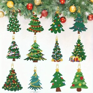 May include: A collection of twelve Christmas tree ornaments in various designs. Each green tree is adorned with colorful embellishments and hangs from a gold chain. The ornaments are displayed against a backdrop of festive greenery and red and gold baubles.